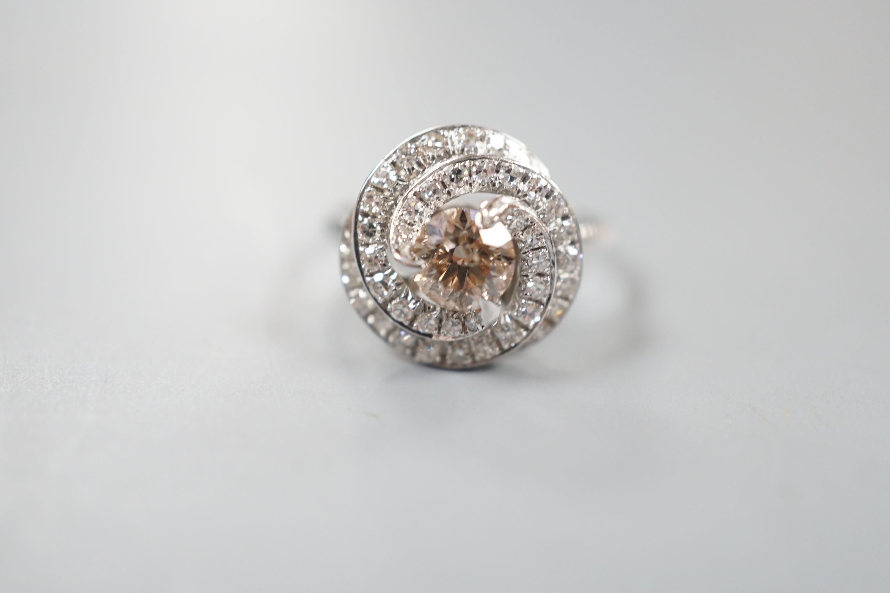 A French white metal(18ct poincon mark) and cognac coloured single stone diamond ring, with diamond set spiral cluster setting, size S, gross 5.5 grams.